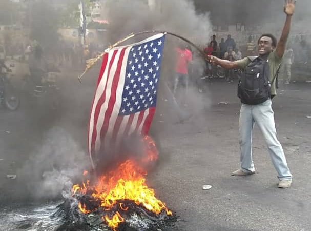 Des manifestants brûlent un drapeau américain